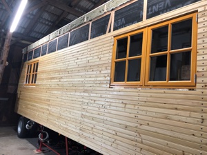 Seitenansicht vom Wagen in der Bauphase. Anbringen der Außenfassade.